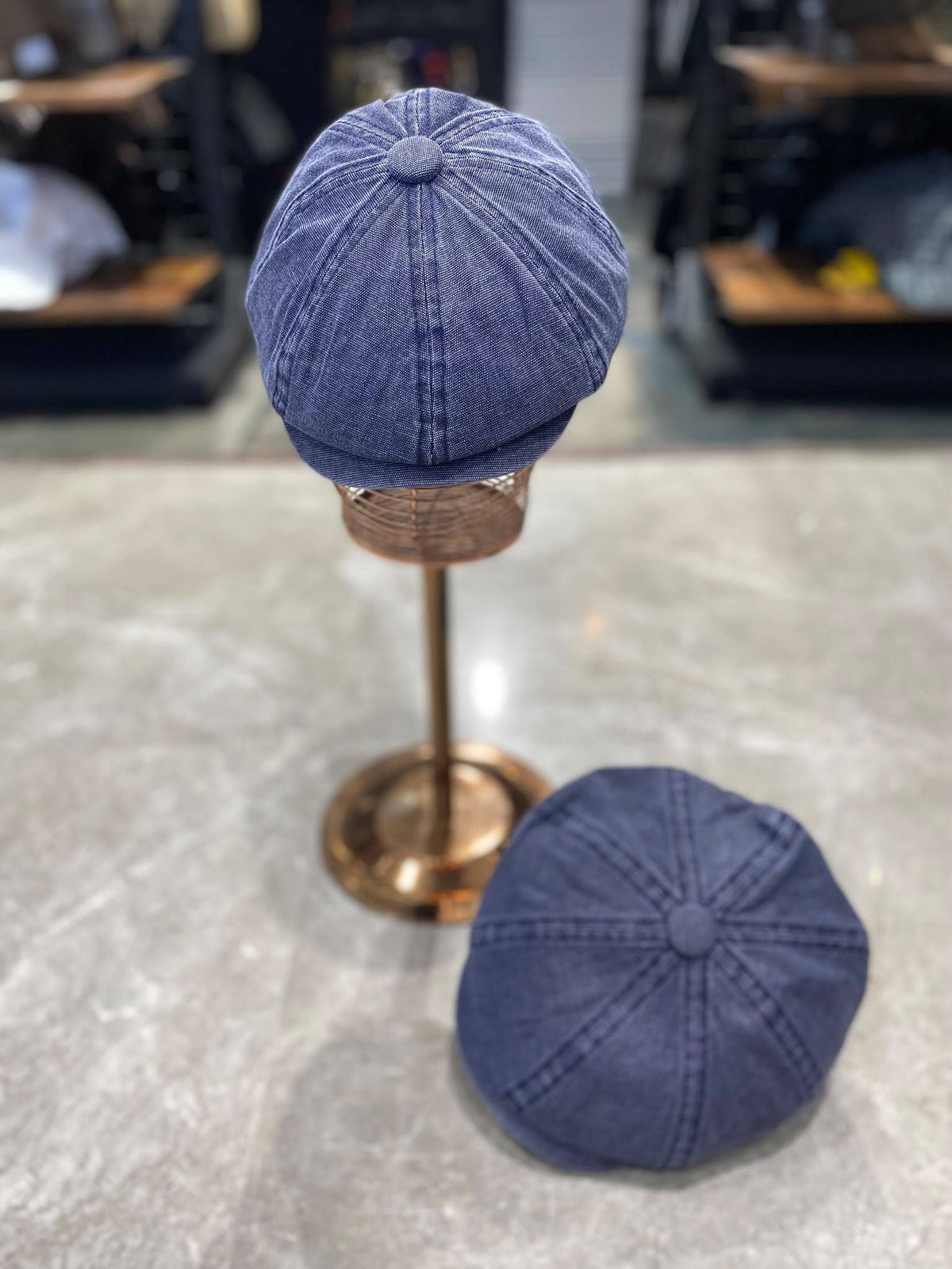 Peaky Blinders tarzı 8 parça kasket, indigo yıkamalı — standda ve yerde iki açıdan